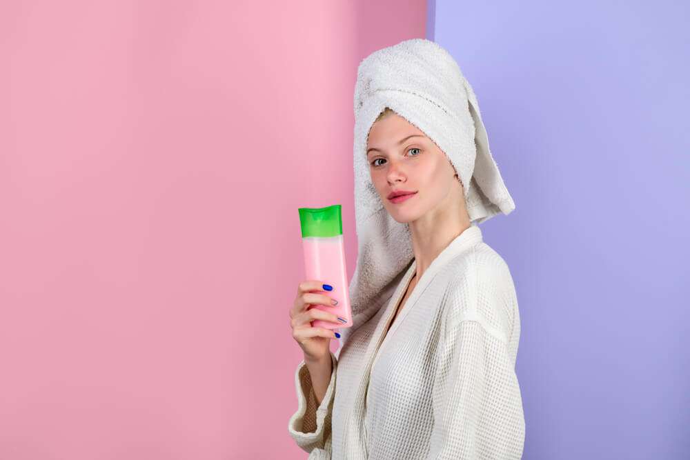 femme tenant un shampoing