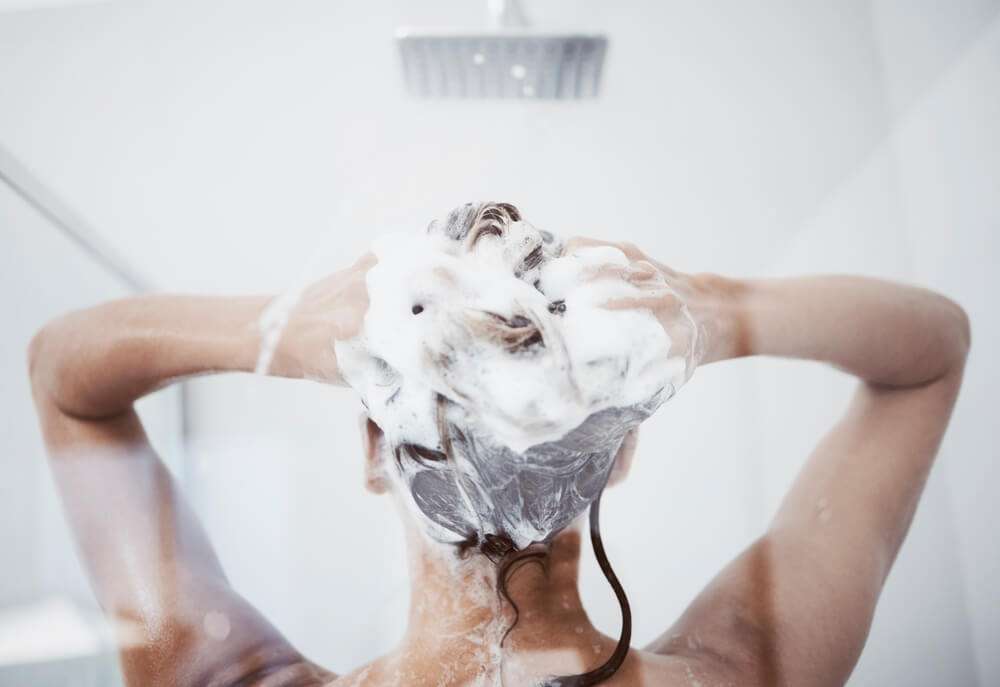 femme appliquant un après shampoing